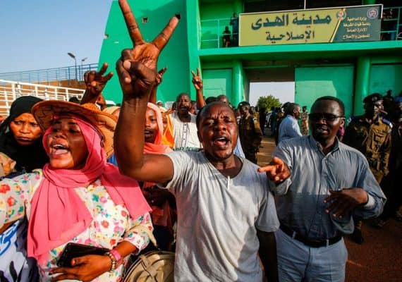 A Sudanese man flashes the victory gesture as people gather outside al-Huda prison in the capital Khartoum's twin city of Omdurman on July 4, 2019, during a ceremony marking the release of 235 members of a faction of the Sudan Liberation Army, which has fought government forces in war-torn Darfur.