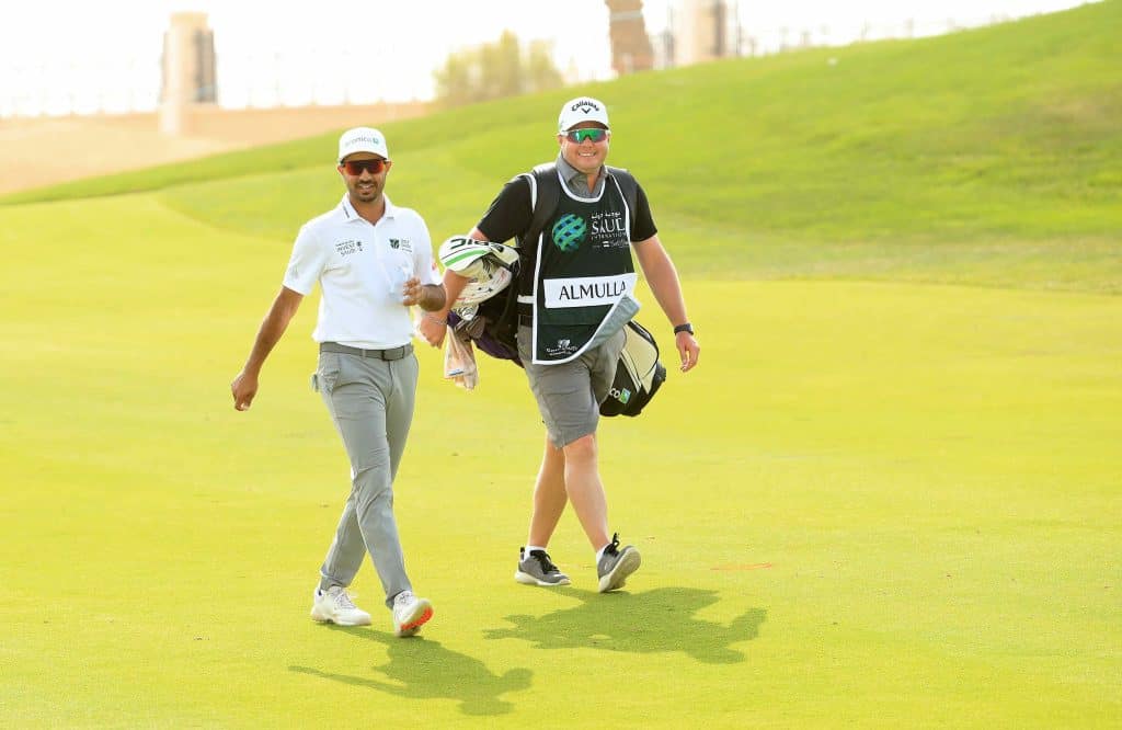 Othman Almulla of Saudi Arabia and his caddie walk down the 9th fairway during Day One of the Saudi International
