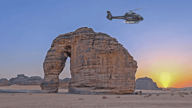 A helicopter from the Scenic Eclipse passing Elephant Rock, part of the AlUla site.